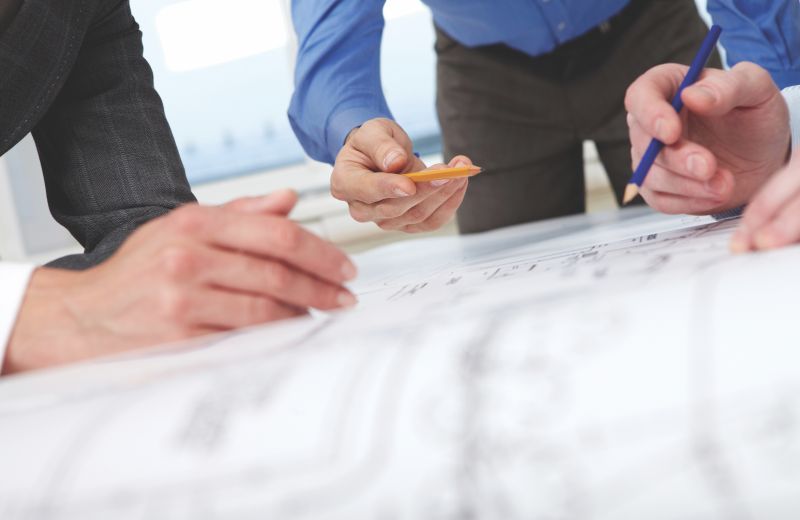 Architect drafting floor plans while planning smart home equipment space and pathways